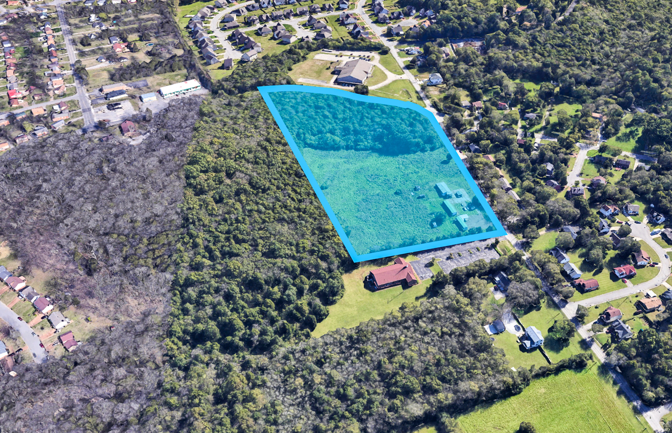 A large green building surrounded by trees.