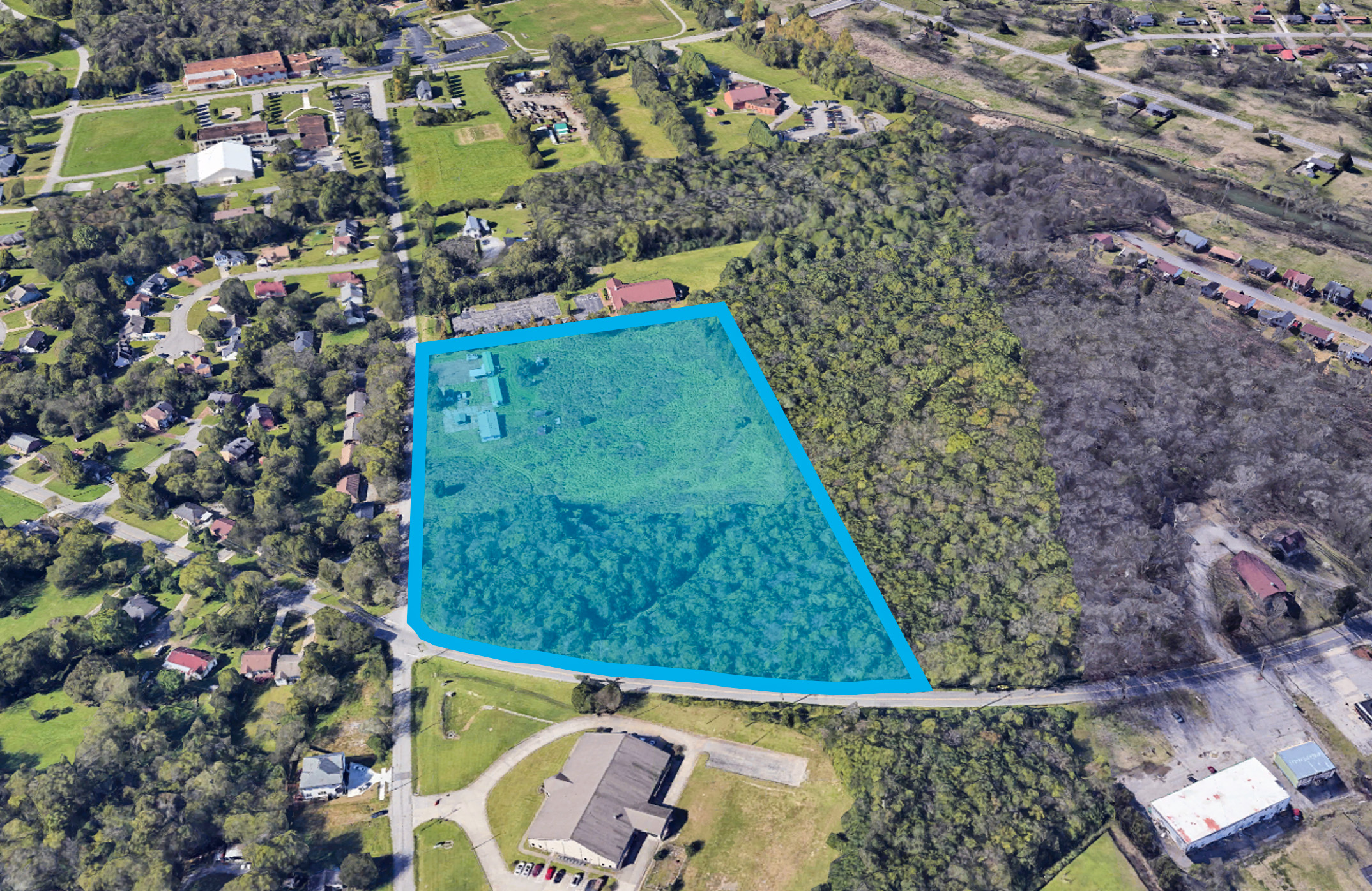 A large green field with a building in the middle.