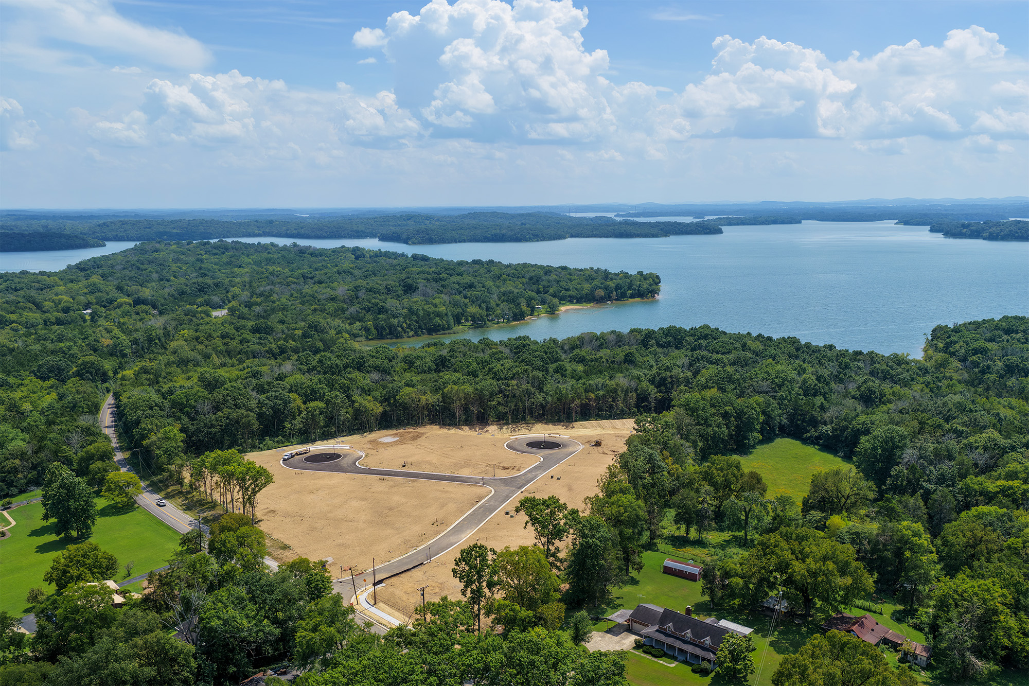 A landscape with trees and a body of water in the background.