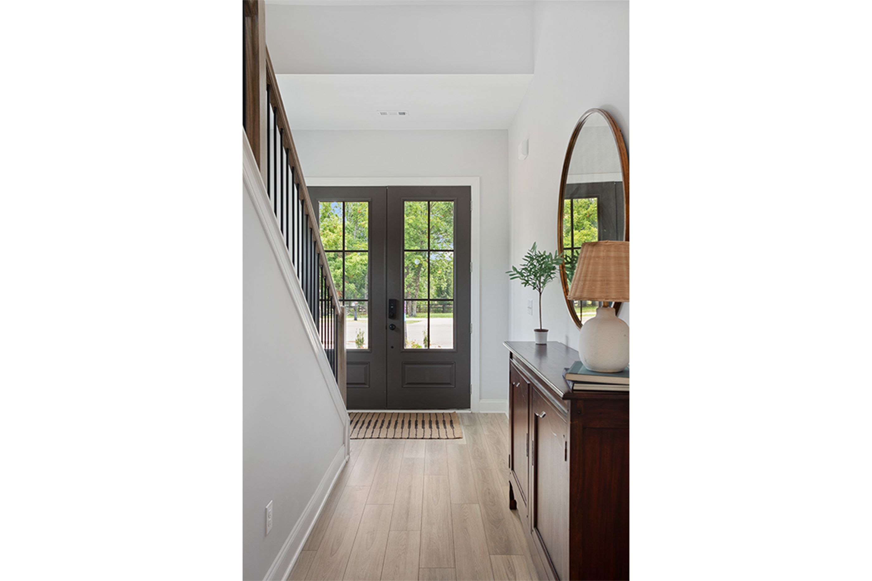 A hallway with a mirror and a lamp.