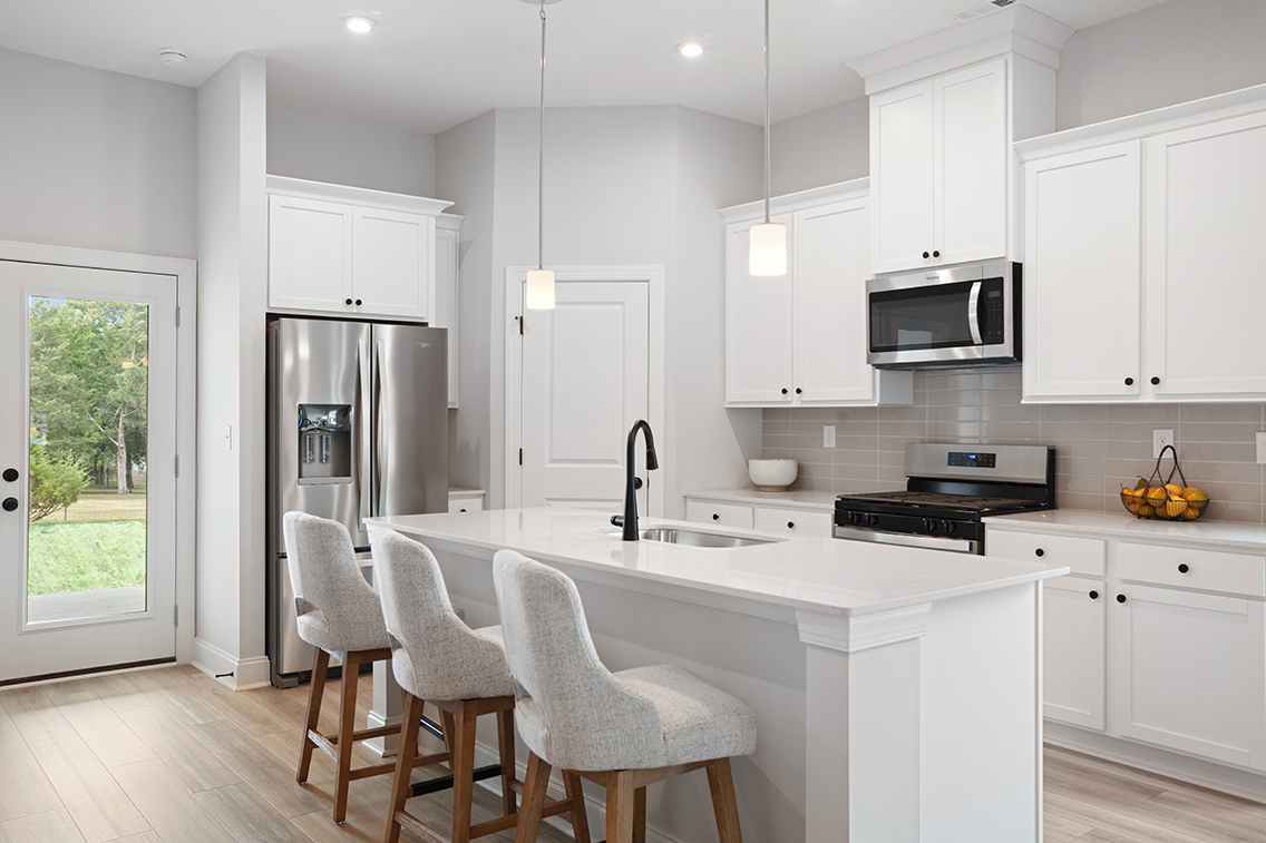 A kitchen with white cabinets.