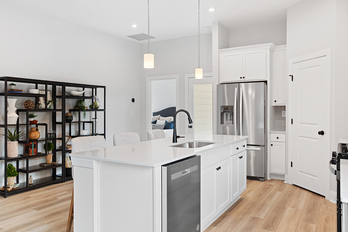 A kitchen with white cabinets.