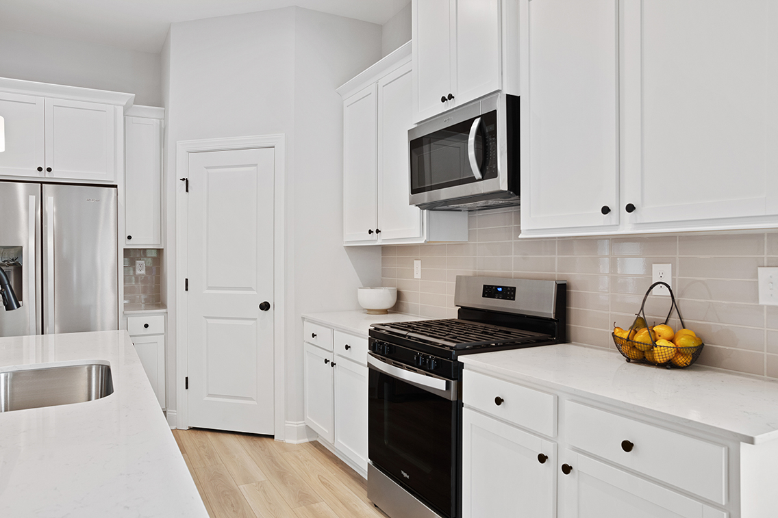 A kitchen with white cabinets.