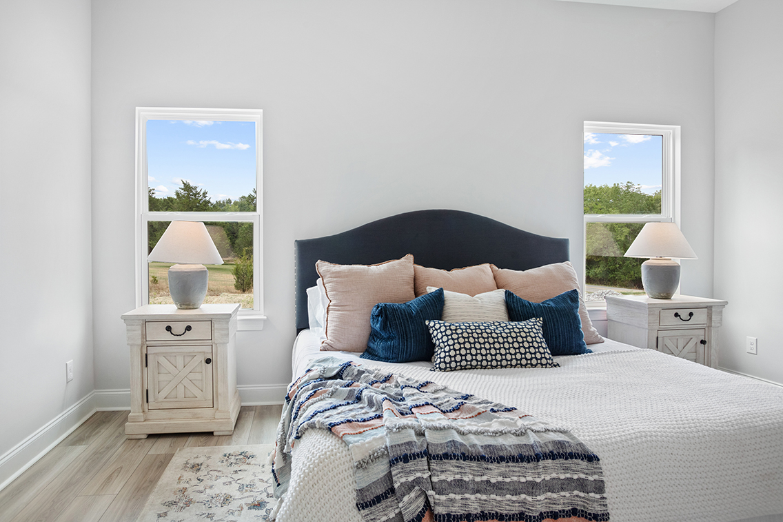 A bed with pillows and lamps.