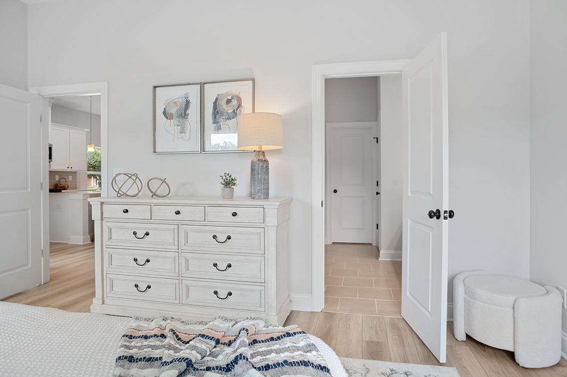 A room with white doors and a white dresser.