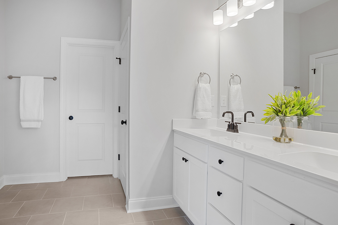A bathroom with white cabinets.