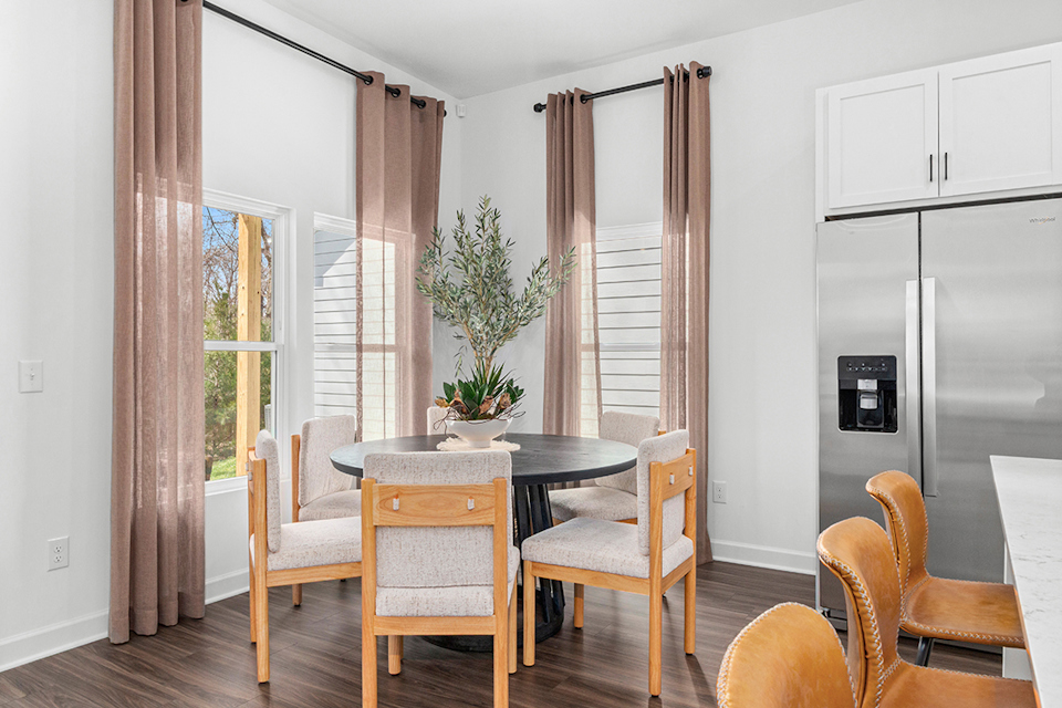 A dining room with a table and chairs.