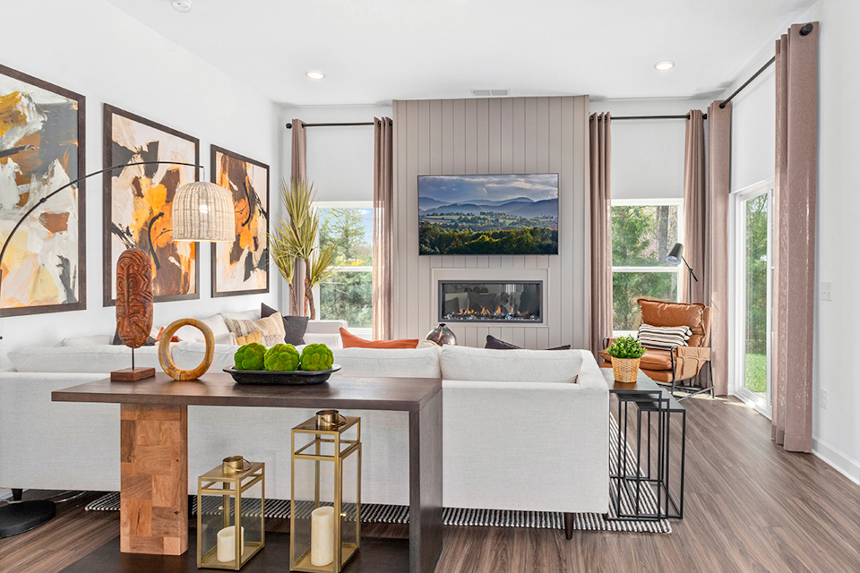 A living room with a white couch and a table with a white table.