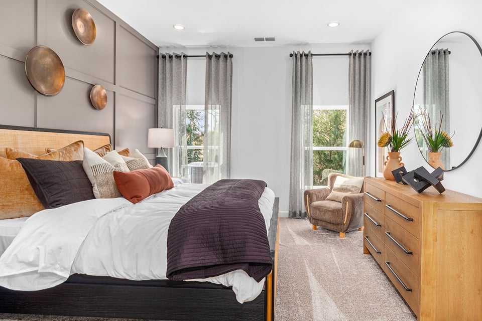 A bedroom with a bed and a mirror.