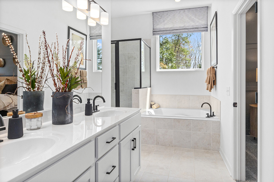 A bathroom with a tub sink and mirror.