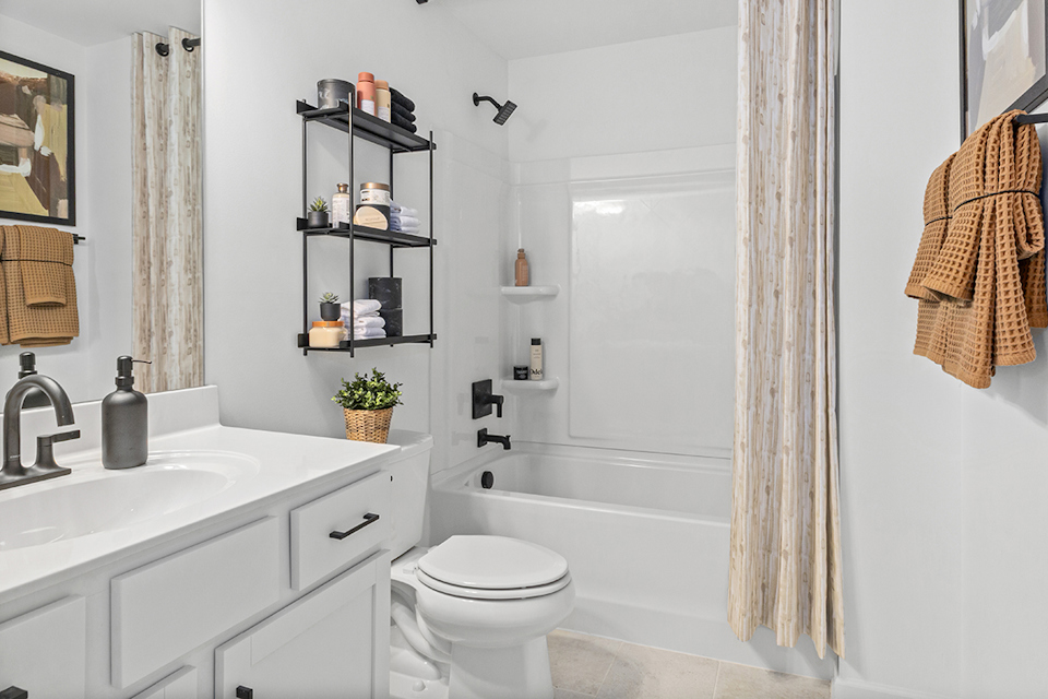 A bathroom with a tub sink and toilet.