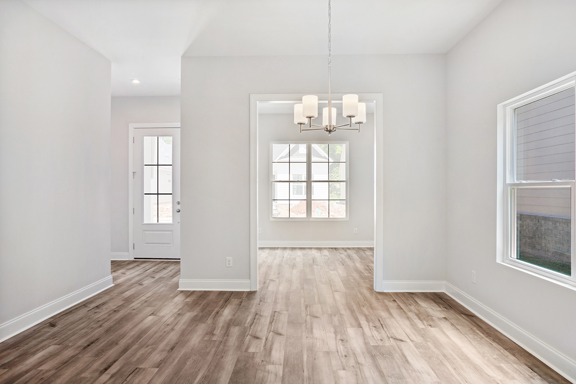 A room with a wood floor and a wood floor with a light fixture.