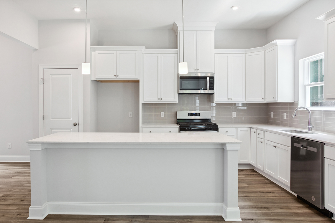 A kitchen with white cabinets.