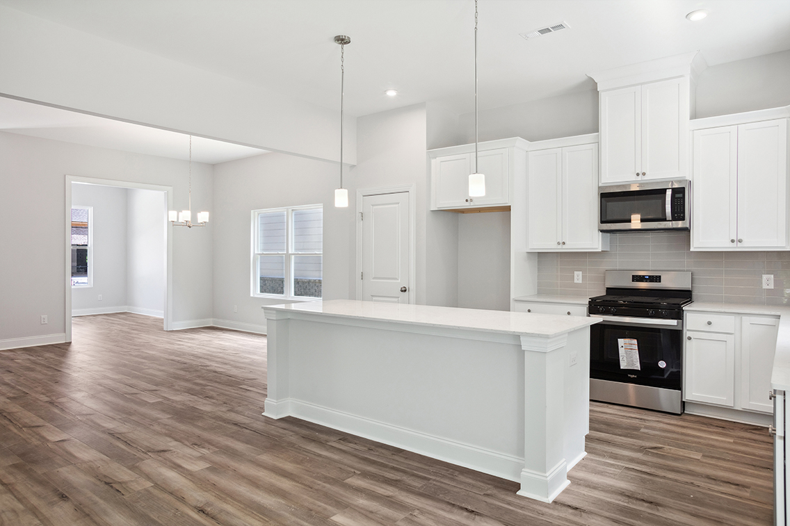 A kitchen with white cabinets.