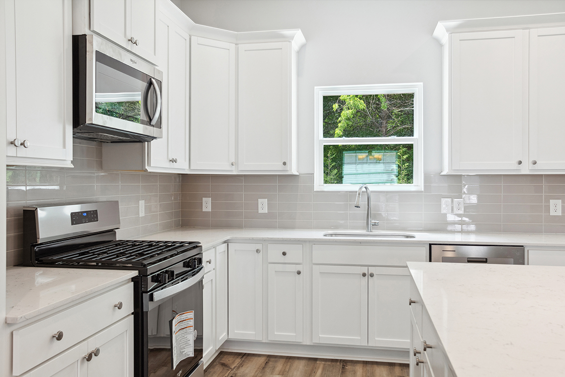 A kitchen with white cabinets.