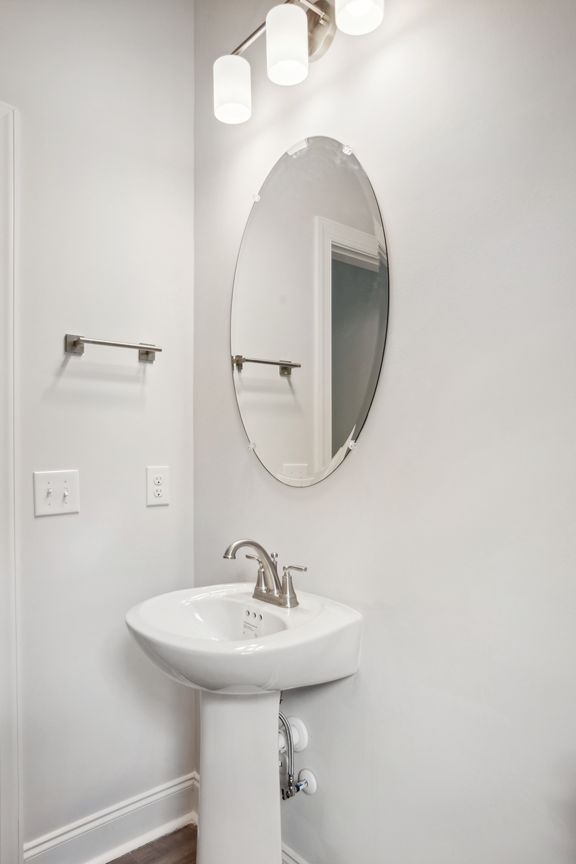 A bathroom with a round mirror.