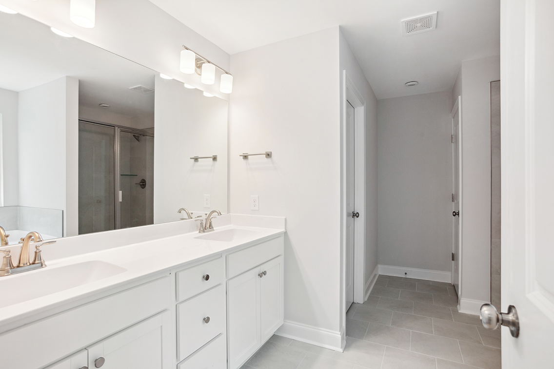 A bathroom with white cabinets.