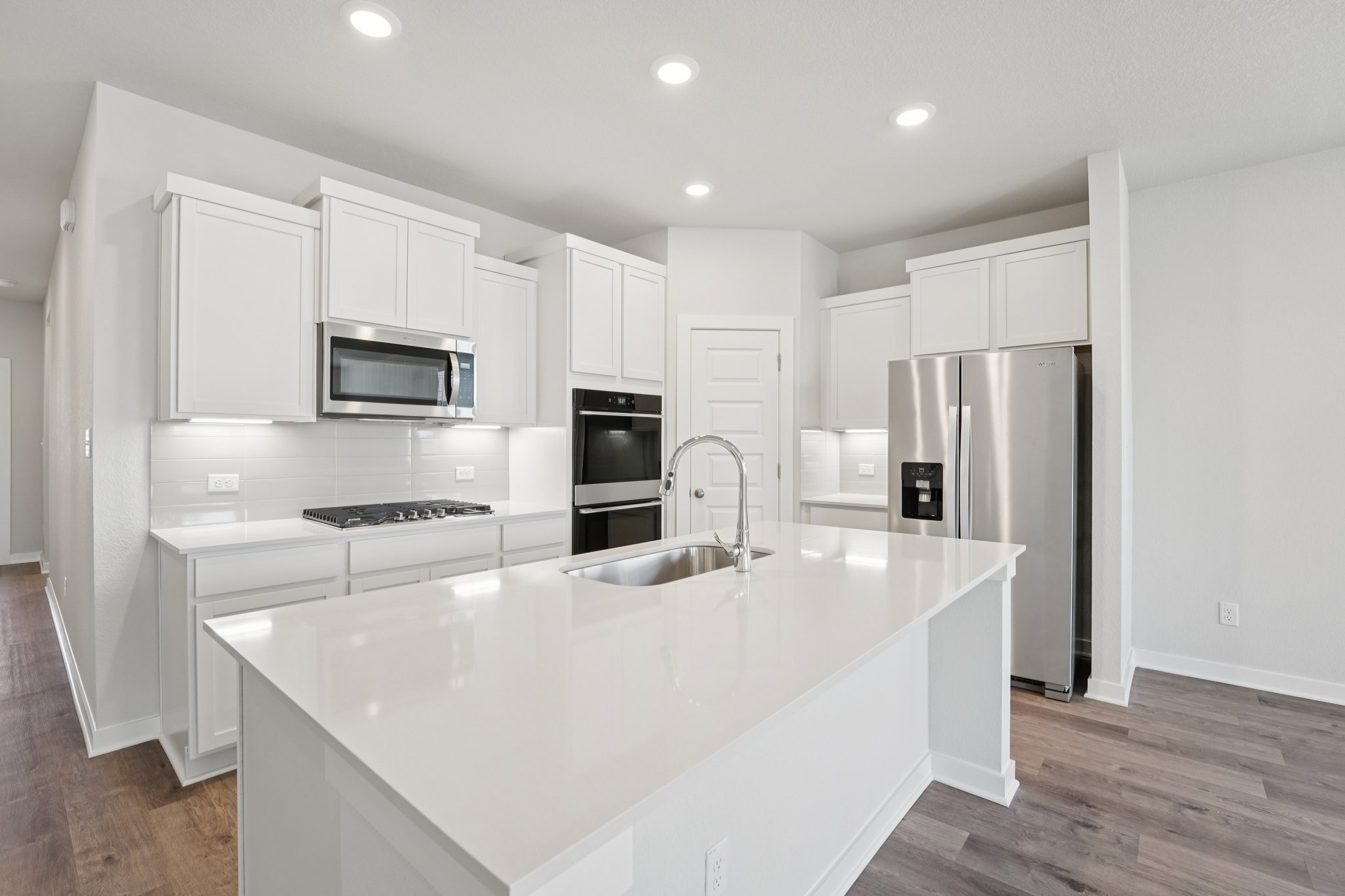A kitchen with white cabinets.