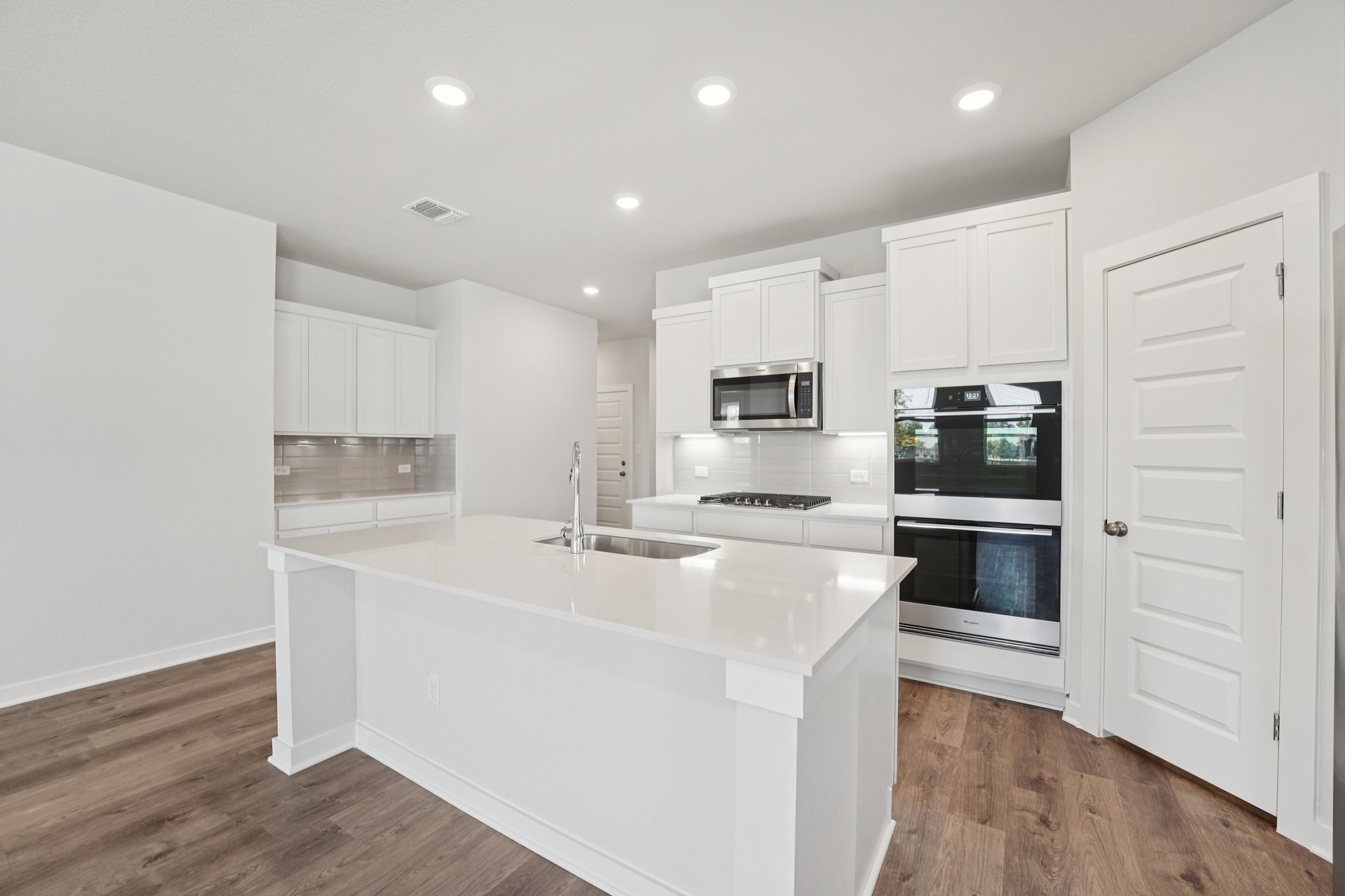 A kitchen with white cabinets.