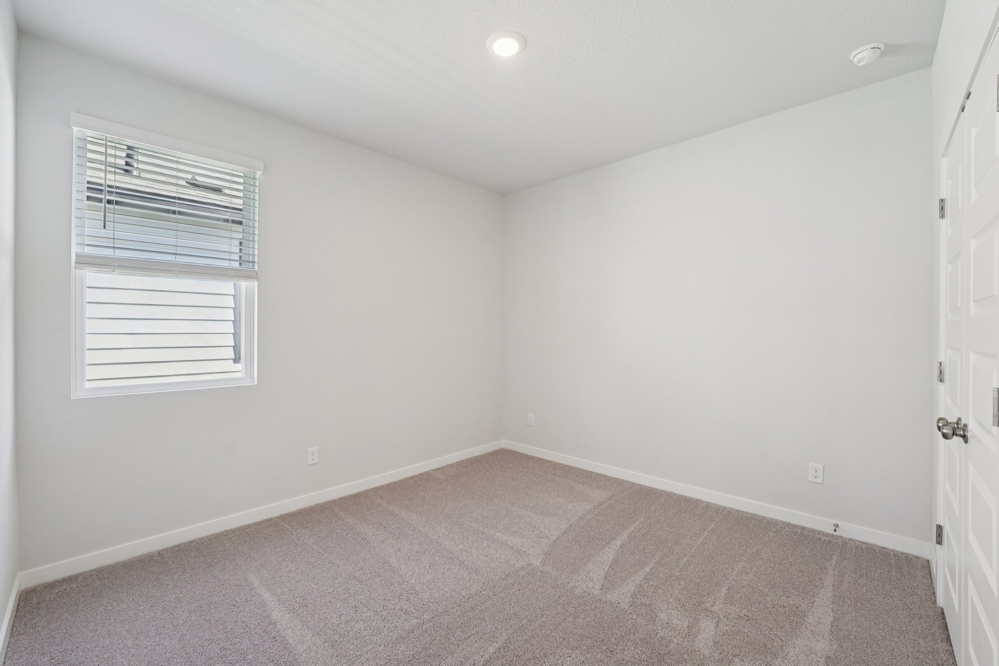 A room with a carpet and a window.