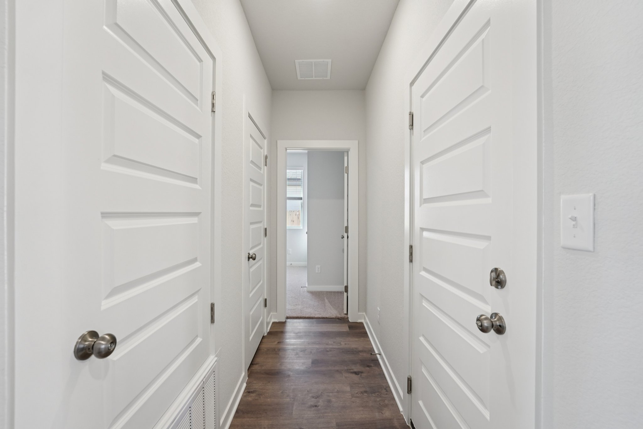 A hallway with white doors.