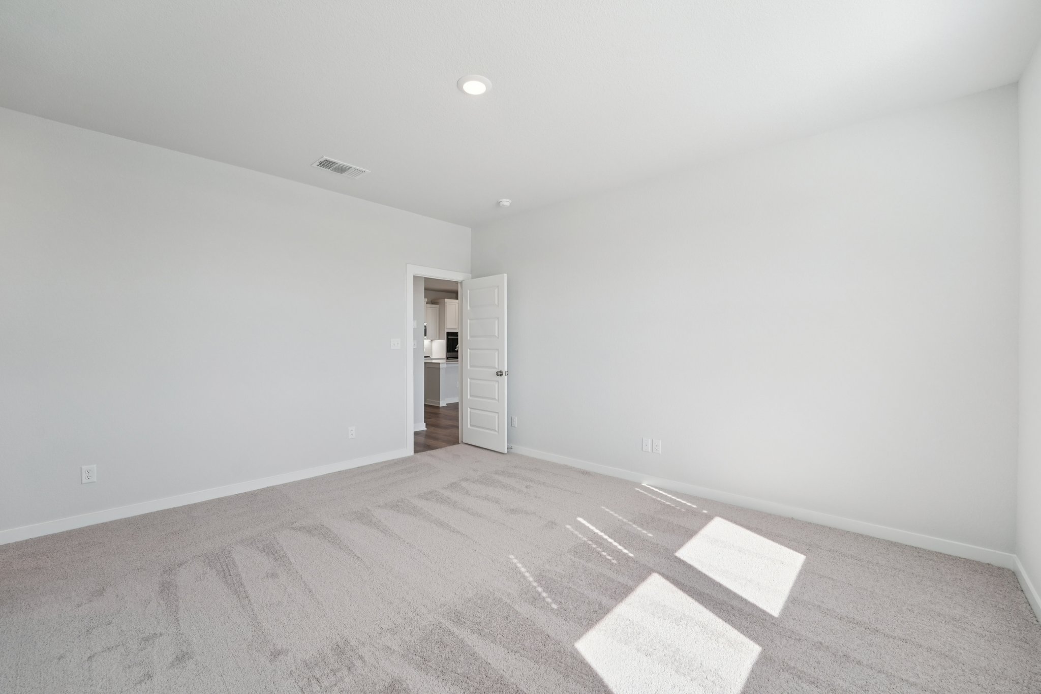 A room with a carpet and a door.