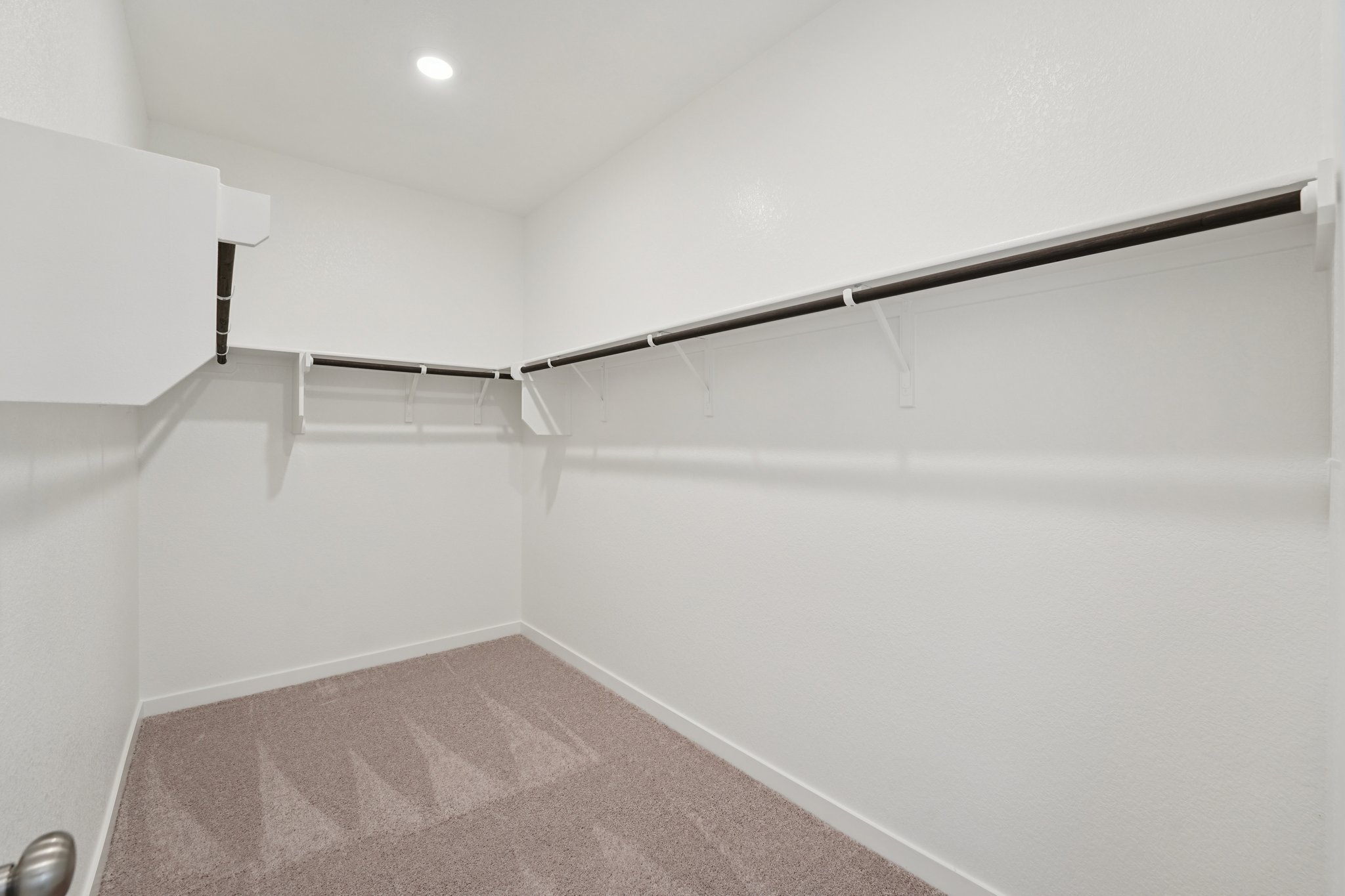 A white wall with a metal bar.