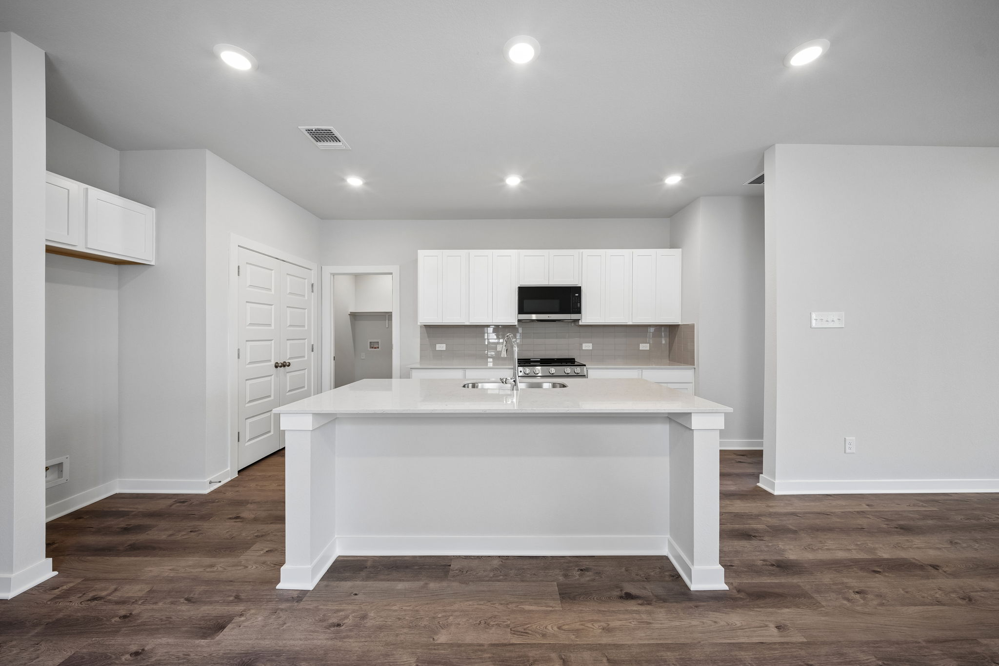 A kitchen with white cabinets.