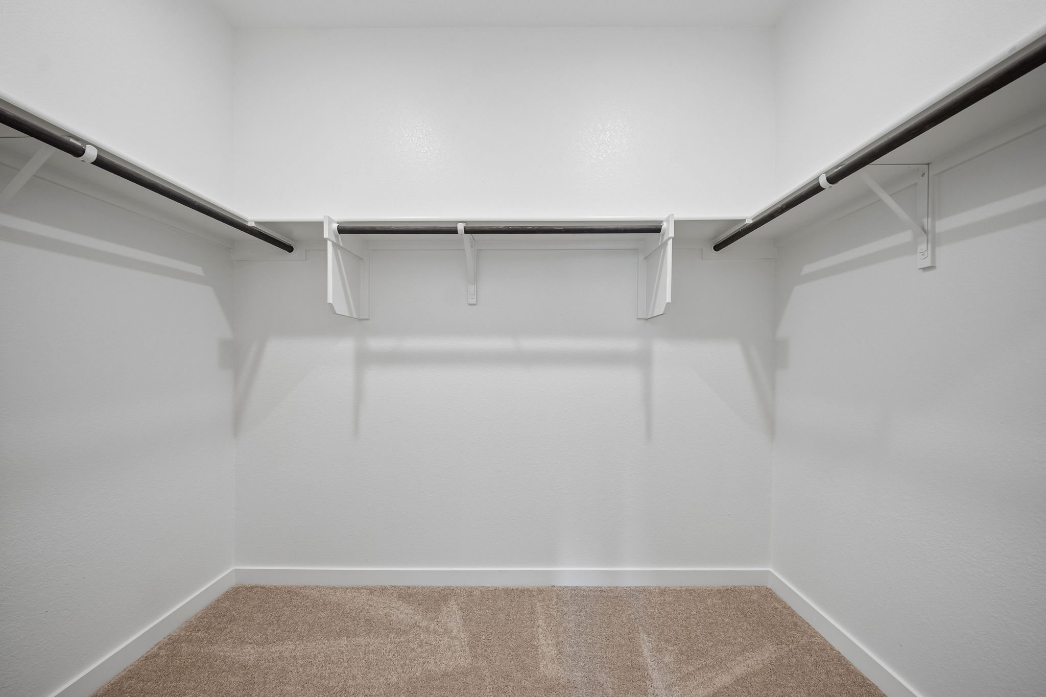 A white wall with a metal railing.