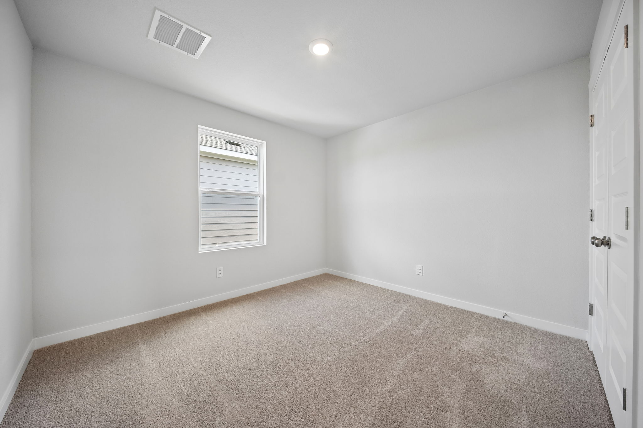 A room with a carpet and a door.