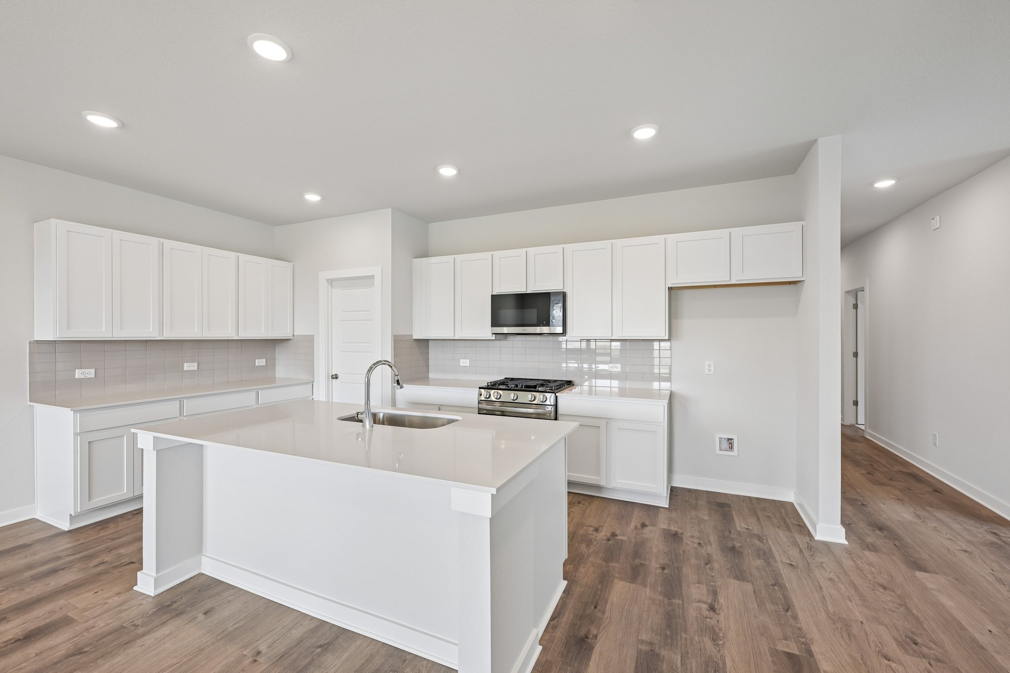 A kitchen with white cabinets.