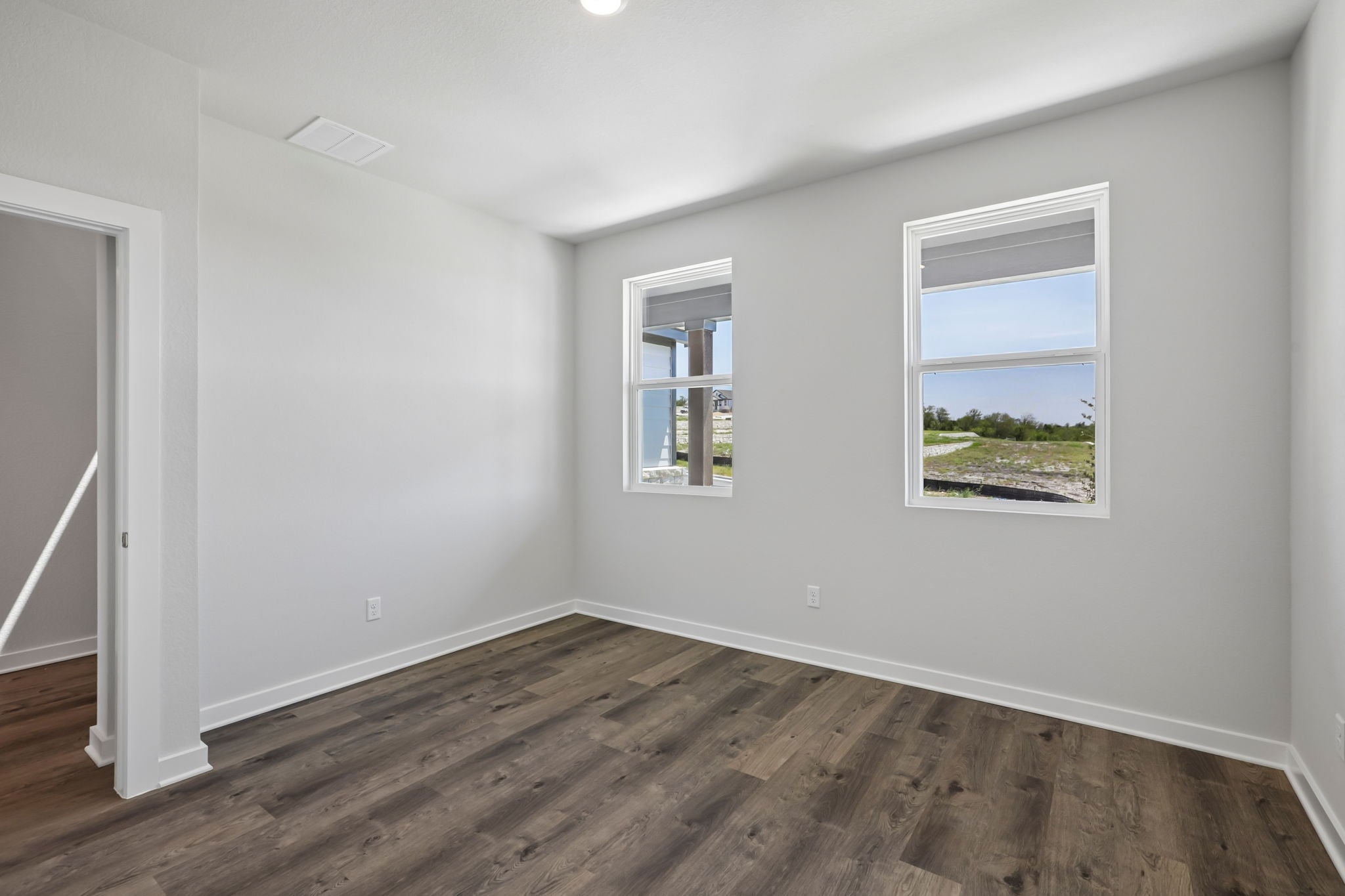 A room with a wood floor and windows.
