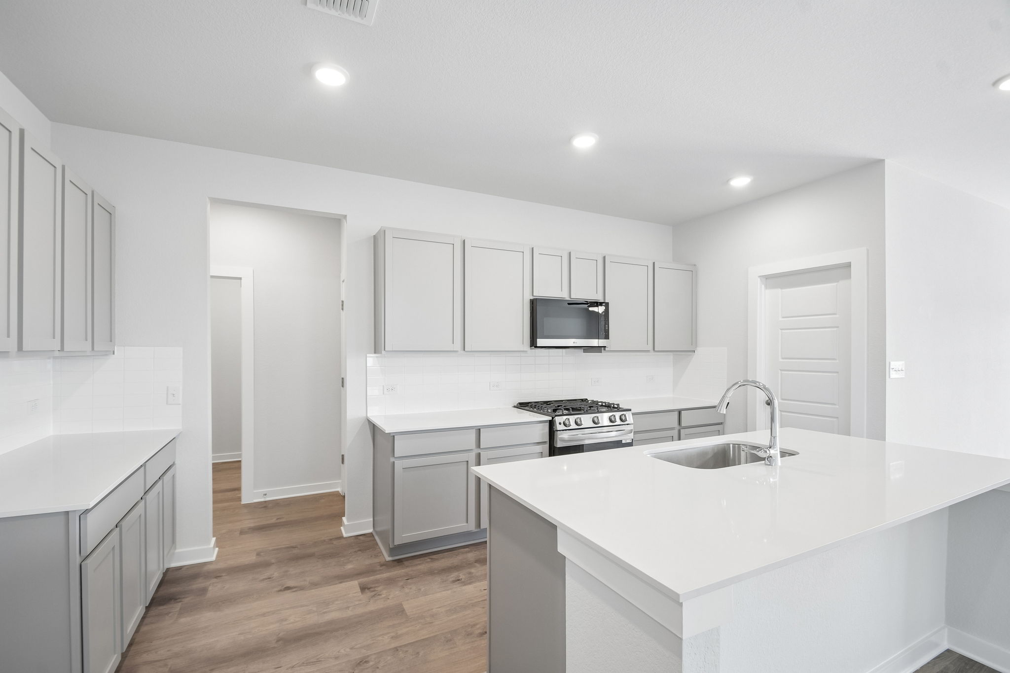A kitchen with white cabinets.