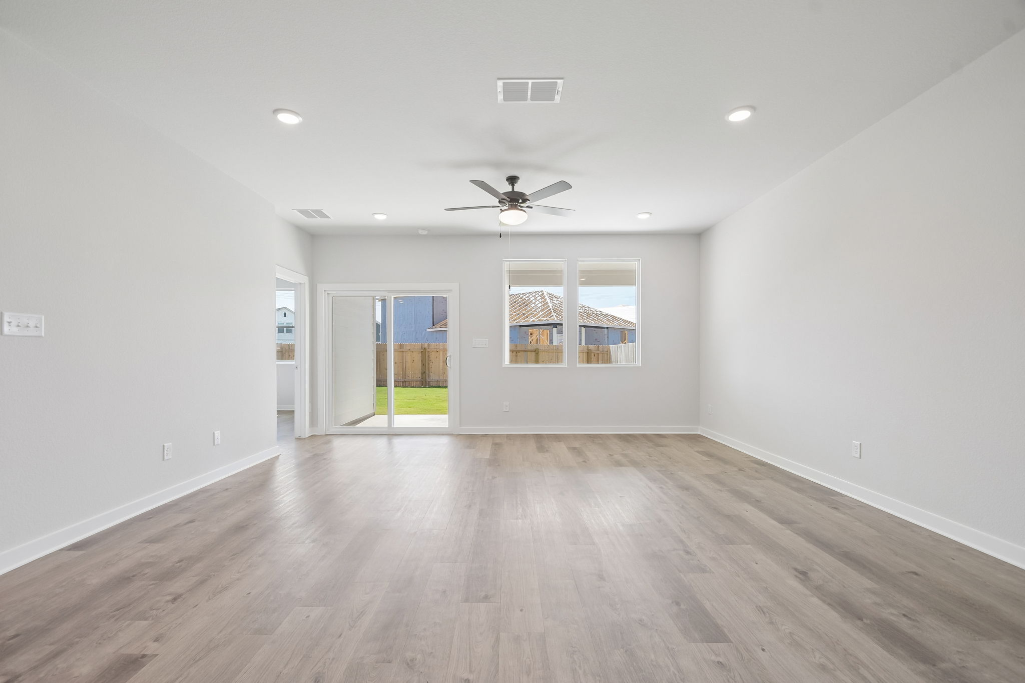 A room with a wood floor and a ceiling fan.