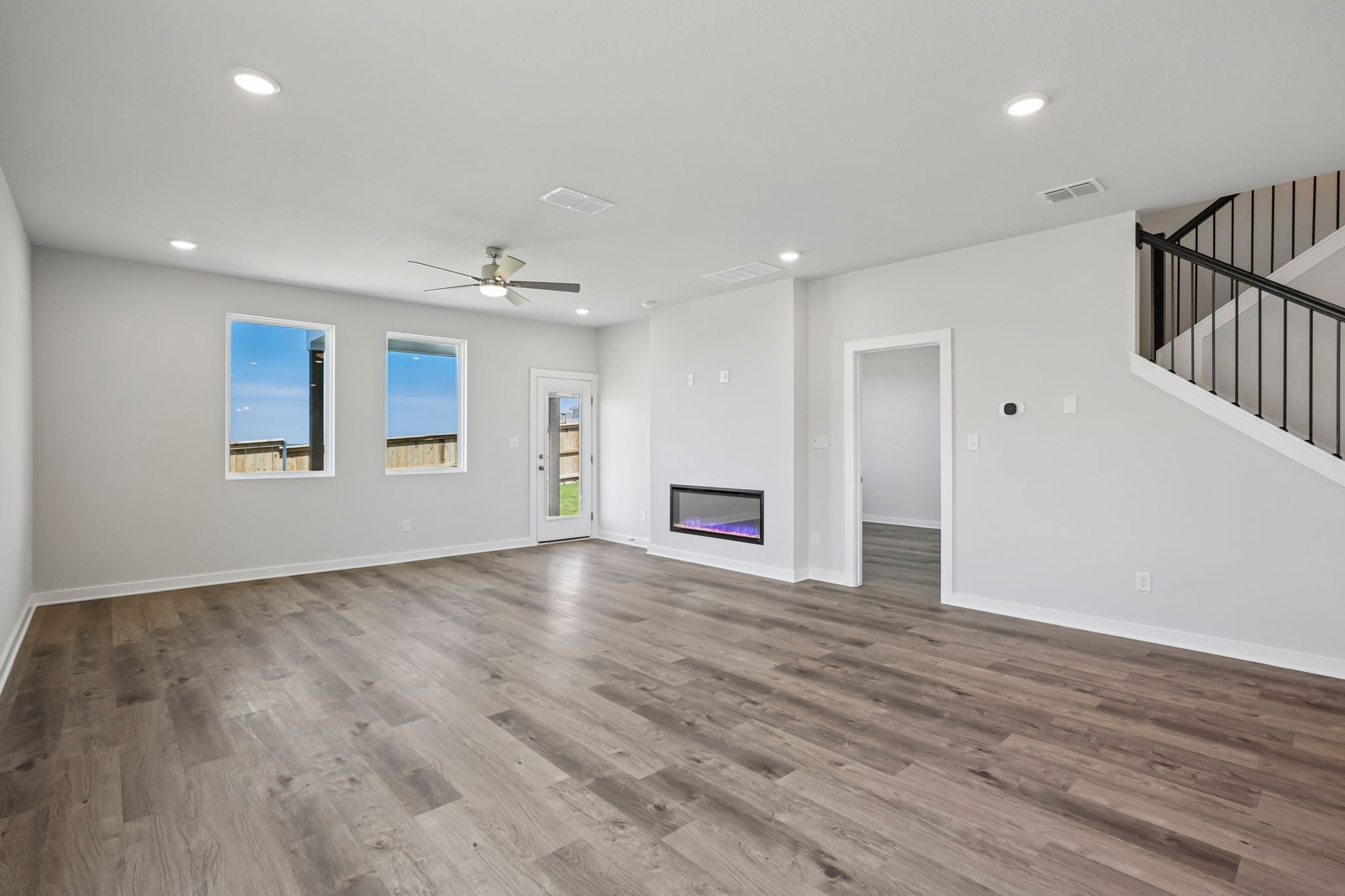 A large empty room with a wood floor and a wood floor.