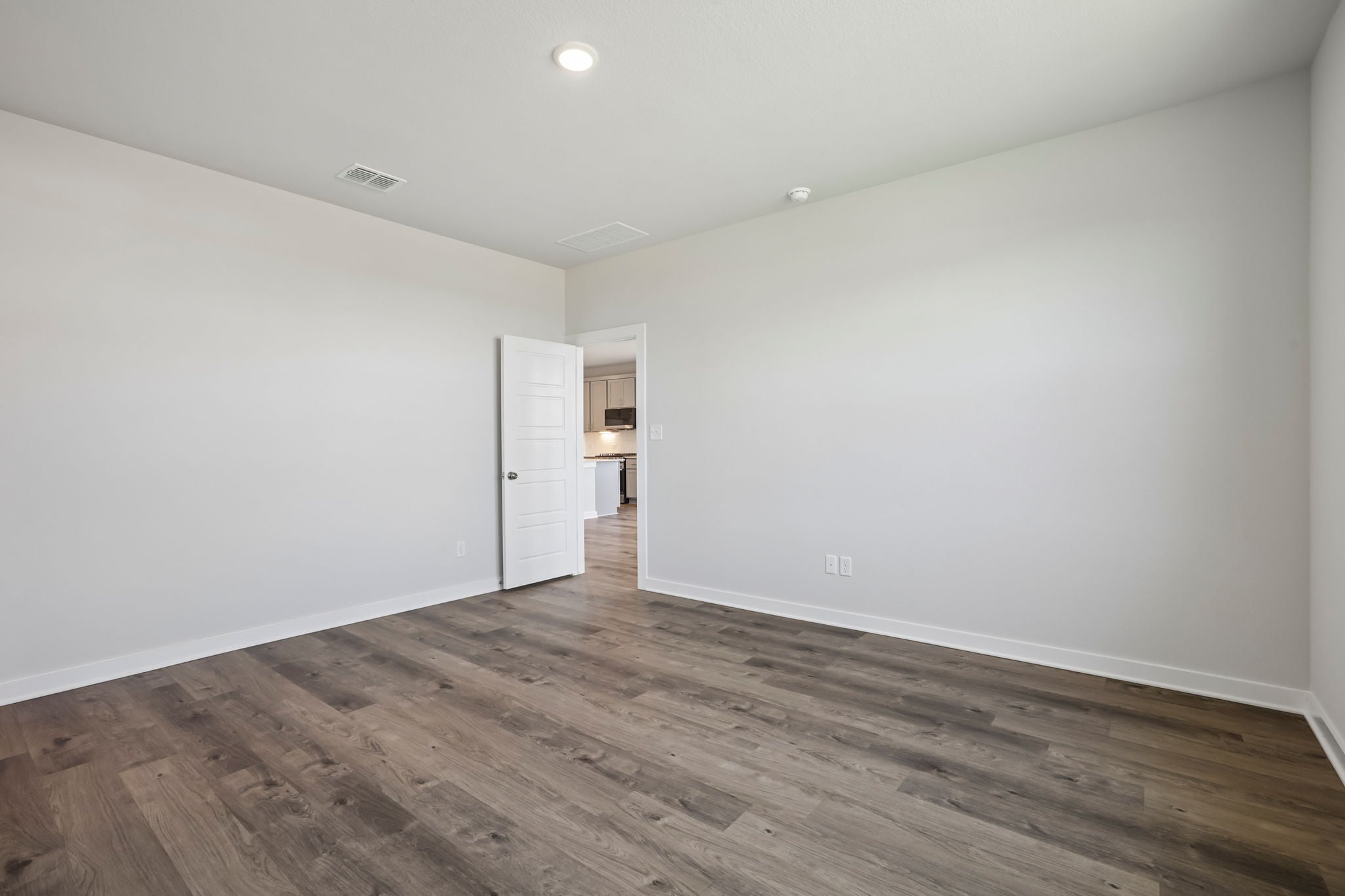 A room with a wood floor and a white door.