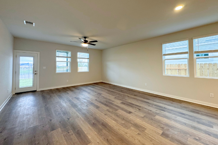 A room with a wood floor and a ceiling fan.