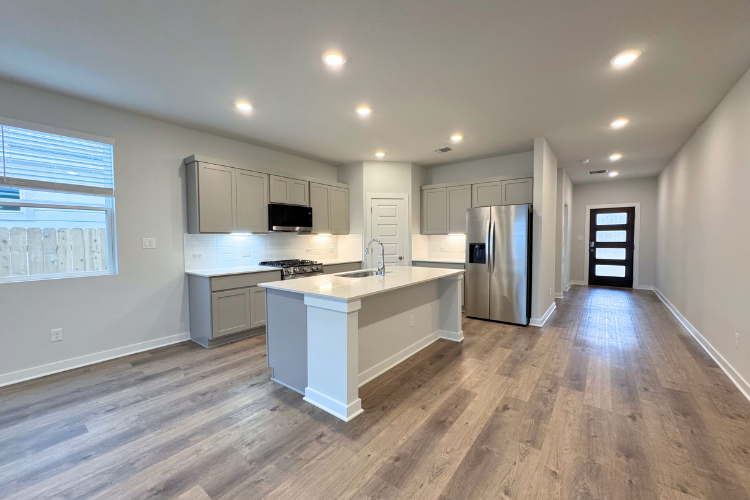 A kitchen with white cabinets.