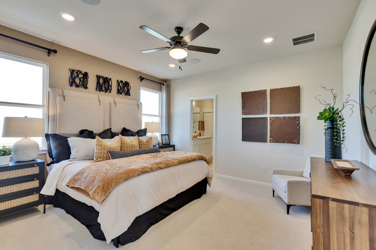 A bedroom with a bed and a fan.