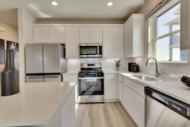 A kitchen with white cabinets.