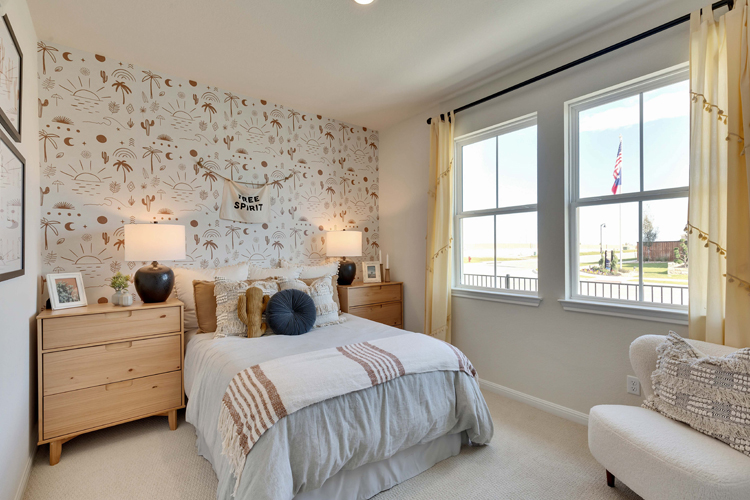 A bedroom with a bed and a chair.