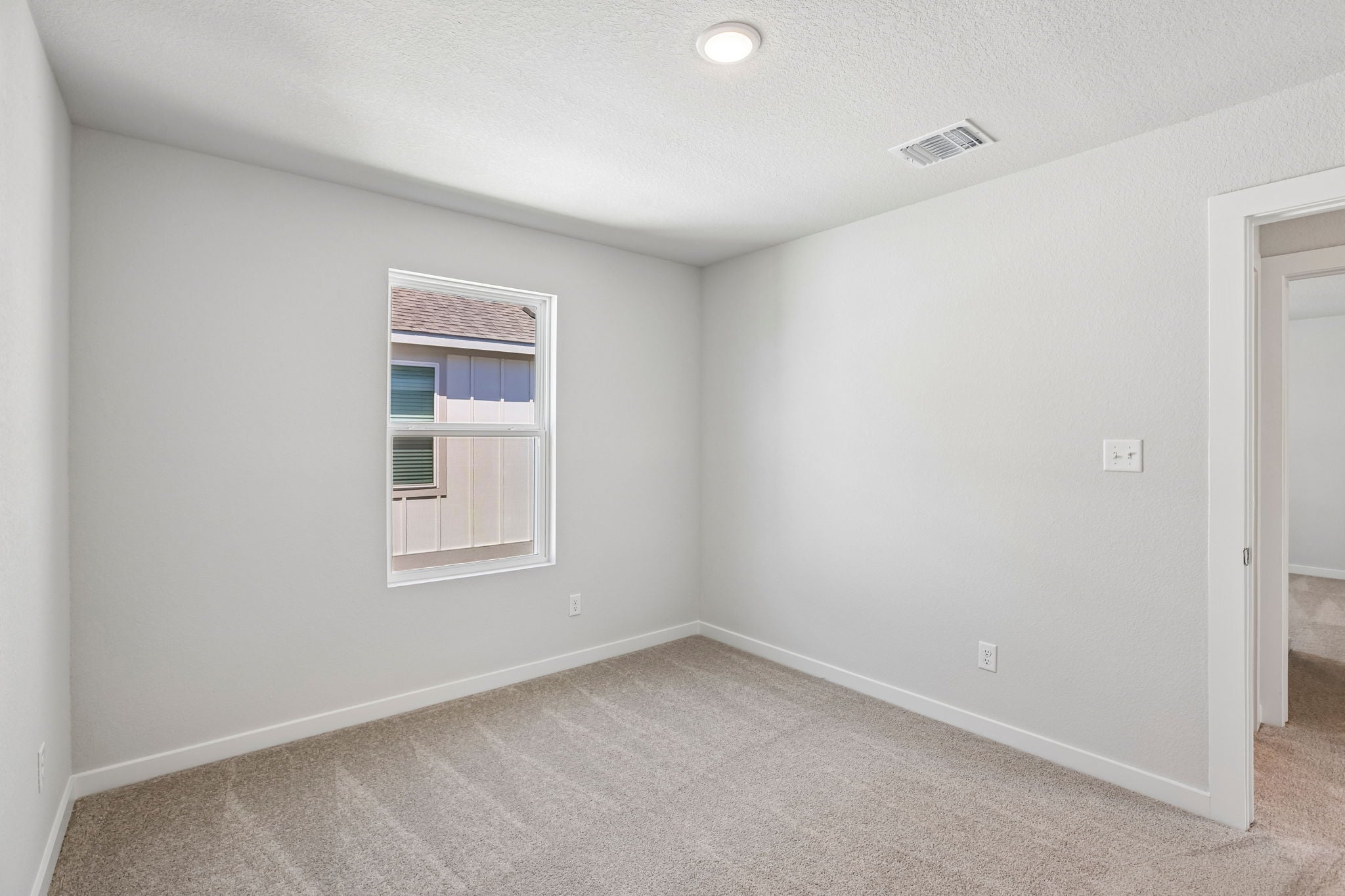 A room with a window and carpet.