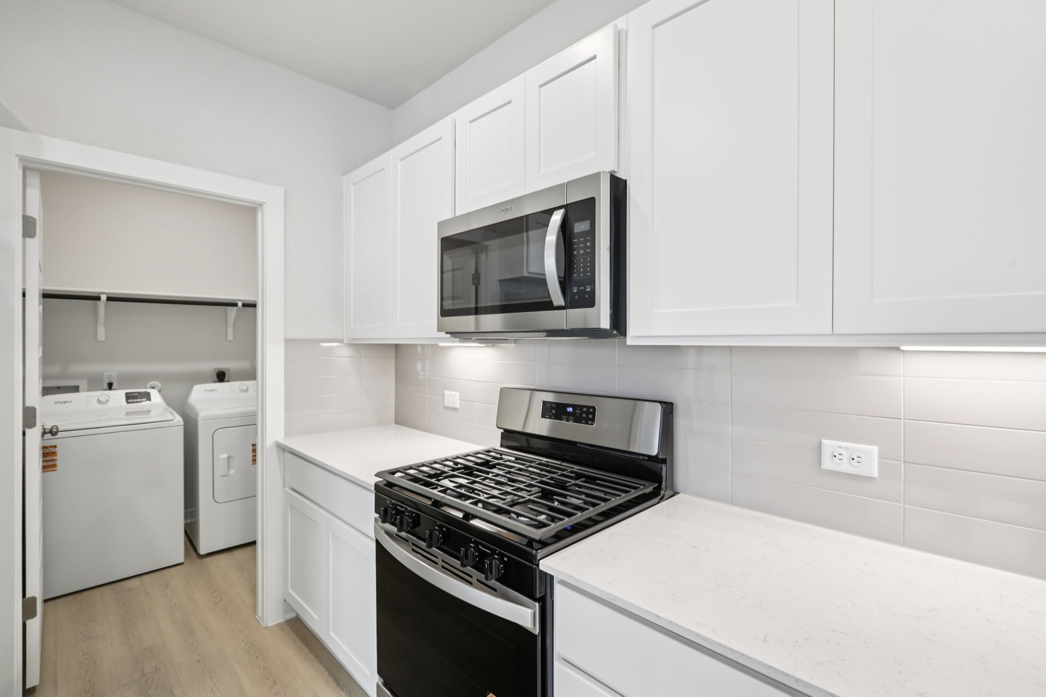 A kitchen with white cabinets.
