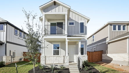 A white house with a tree in front of it.