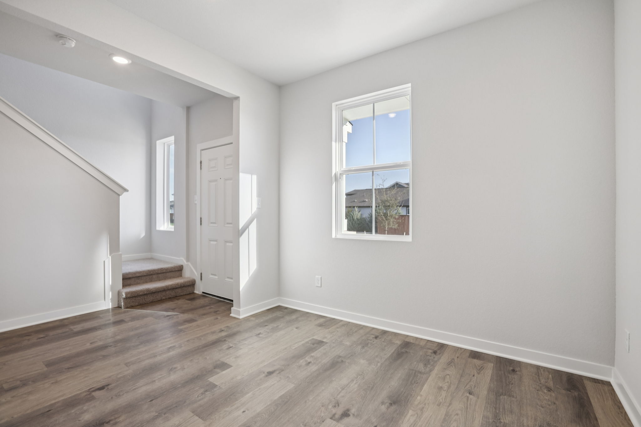 A room with a wood floor and a window.