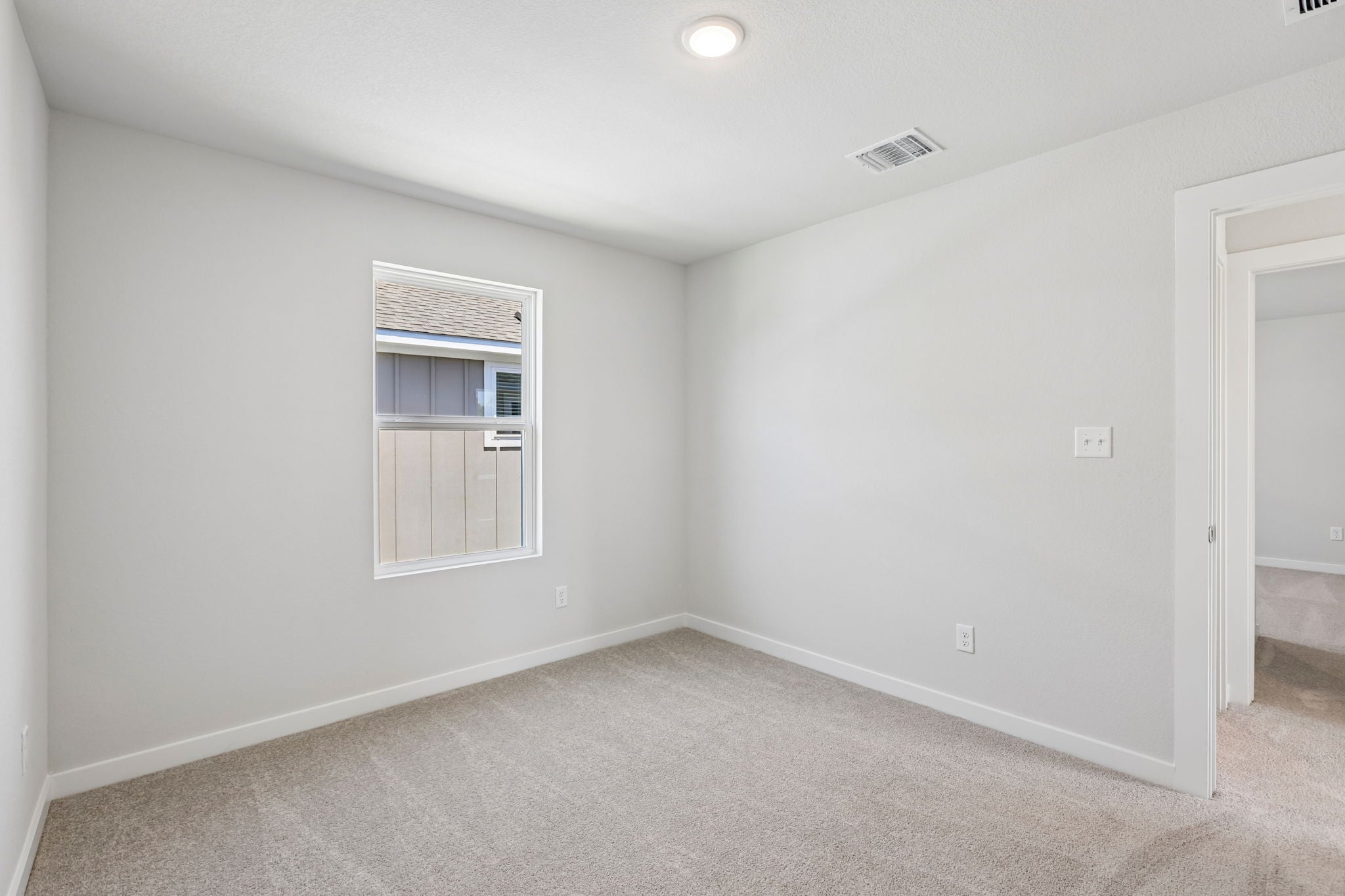 A room with a window and a carpet.