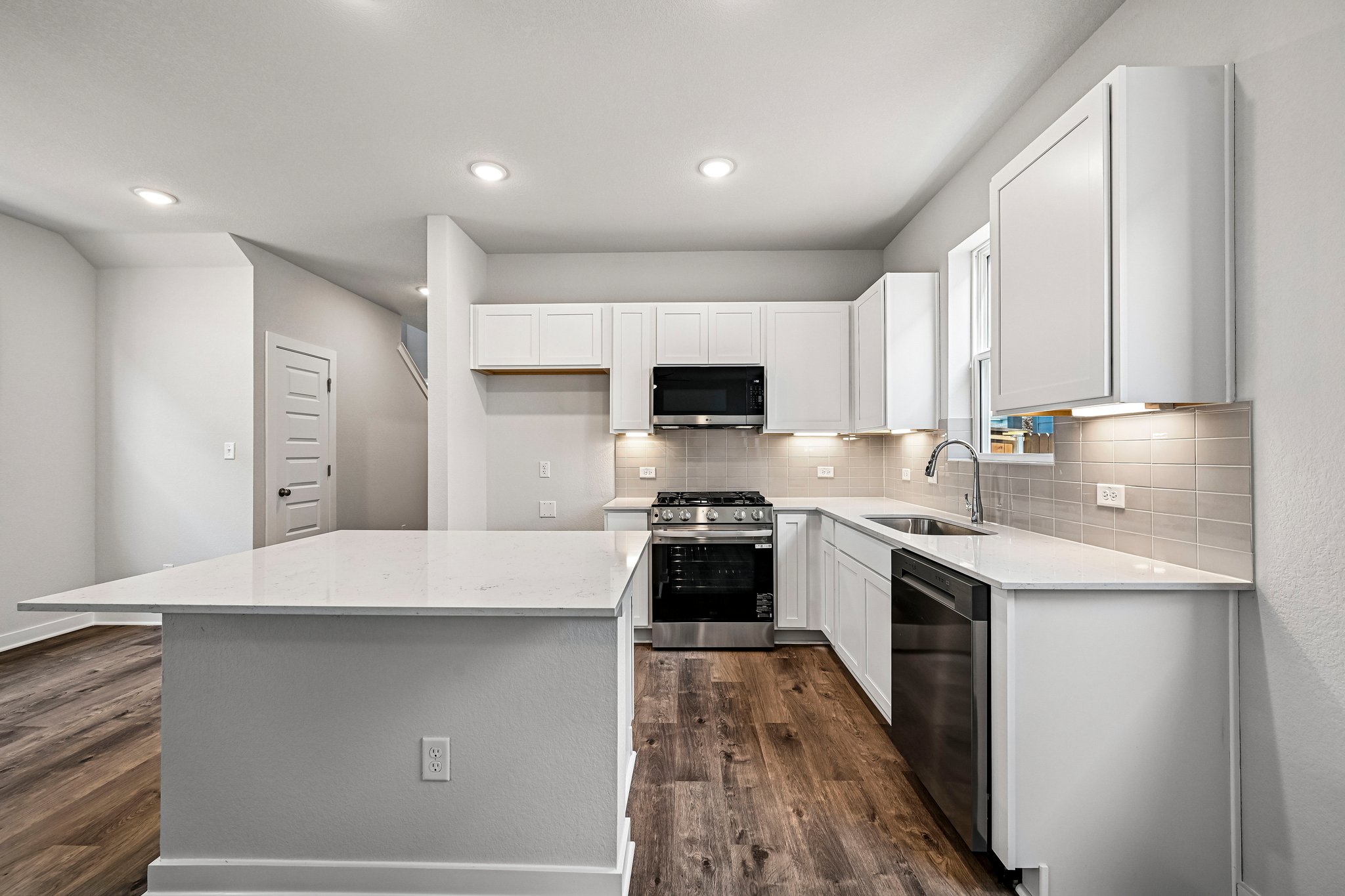 A kitchen with white cabinets.