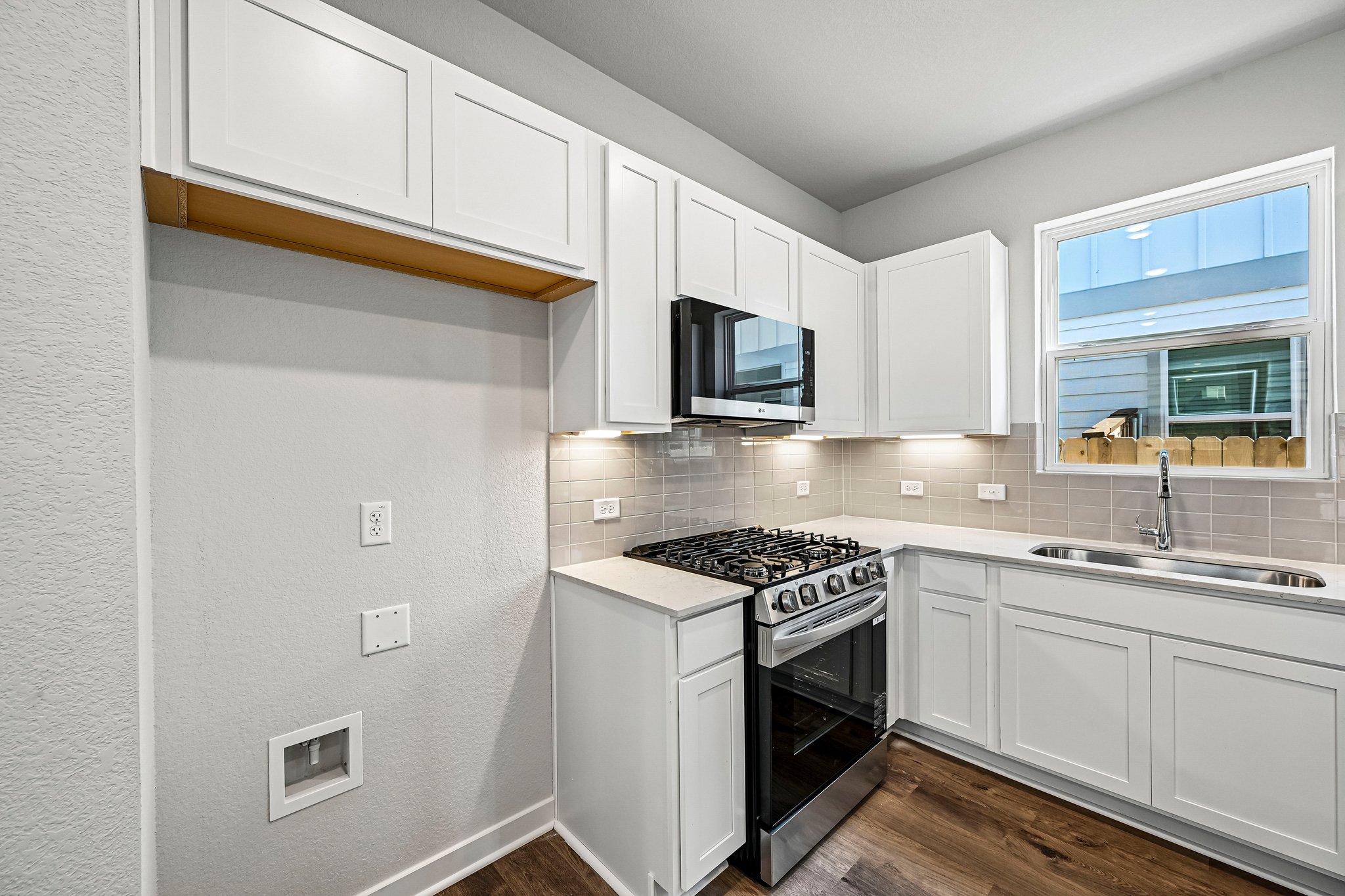 A kitchen with white cabinets.