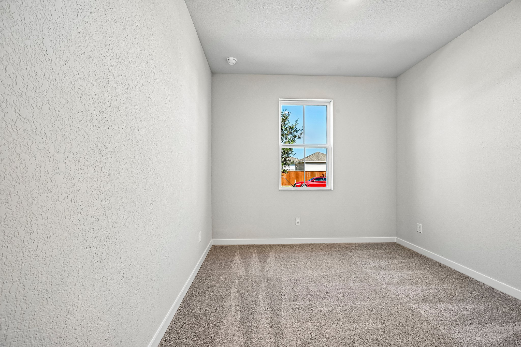 A room with a window and carpet.