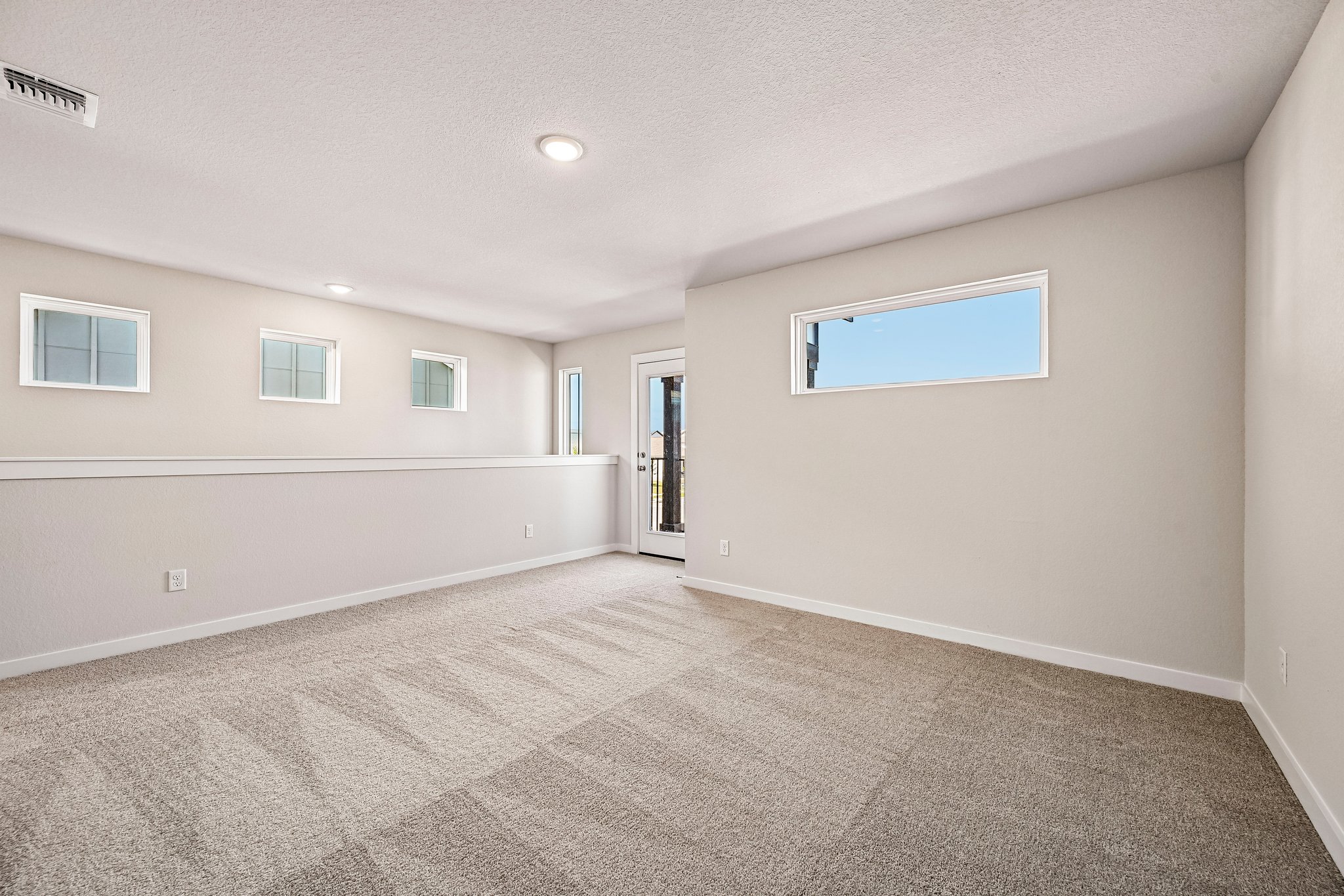 A room with a carpet and a door.